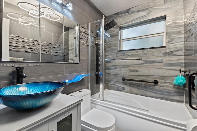 full bathroom with vanity, combined bath / shower with glass door, and toilet