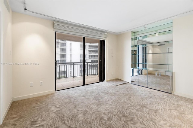 carpeted empty room featuring rail lighting