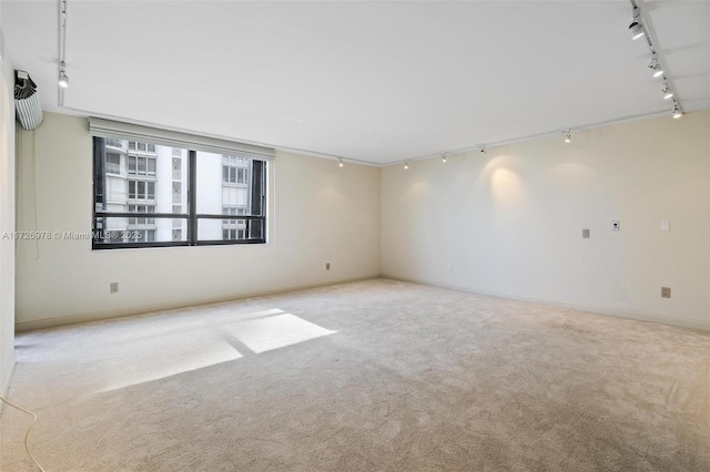 unfurnished room with light carpet and track lighting