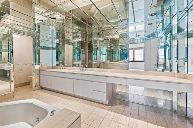 bathroom featuring a washtub, tile patterned floors, toilet, and vanity