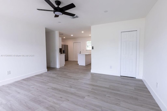 empty room with light wood-type flooring, baseboards, visible vents, and recessed lighting