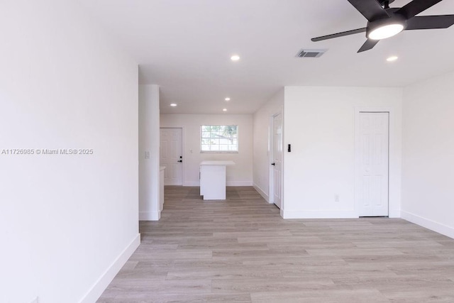 empty room featuring light wood finished floors, visible vents, baseboards, and recessed lighting