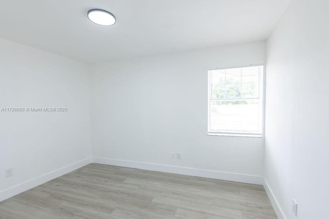 empty room with light wood finished floors and baseboards