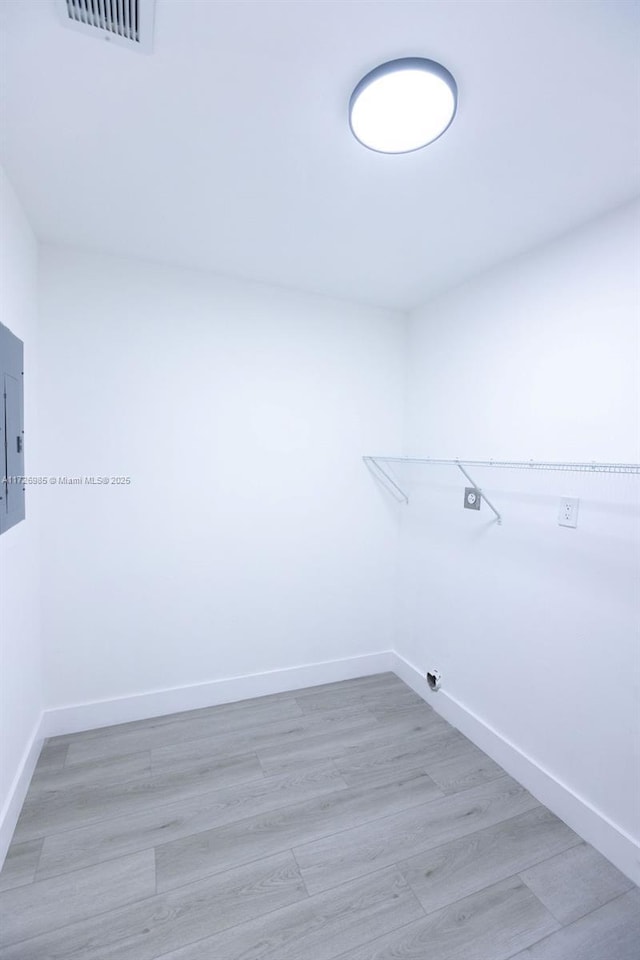 washroom featuring laundry area, visible vents, baseboards, and light wood finished floors