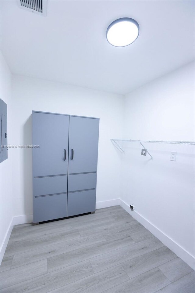 walk in closet featuring light wood-type flooring and electric panel