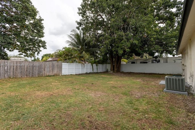 view of yard featuring central AC unit and fence