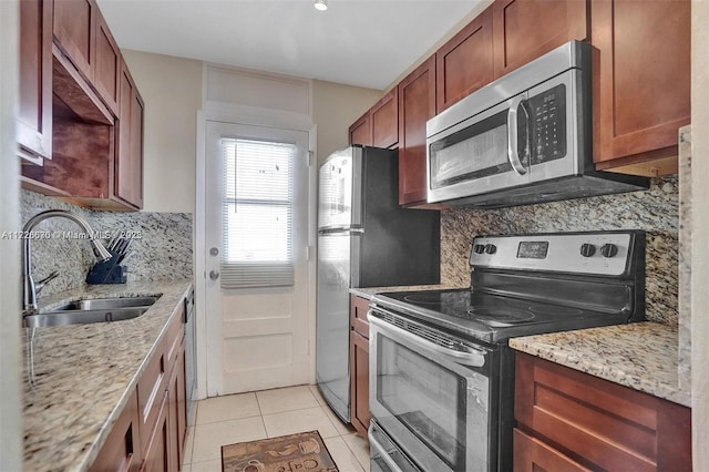 kitchen with tasteful backsplash, light tile patterned floors, sink, and stainless steel appliances