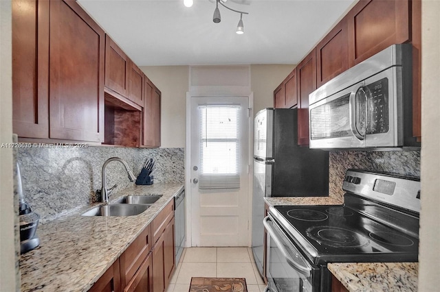 kitchen with decorative backsplash, sink, light tile patterned floors, and stainless steel appliances