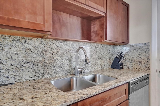 kitchen featuring decorative backsplash, sink, light stone counters, and stainless steel dishwasher