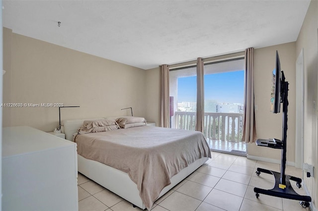 tiled bedroom featuring access to exterior and floor to ceiling windows