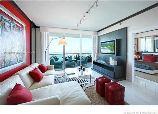 living room featuring a wealth of natural light, expansive windows, and track lighting