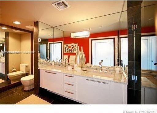 bathroom featuring toilet, vanity, and tile patterned flooring