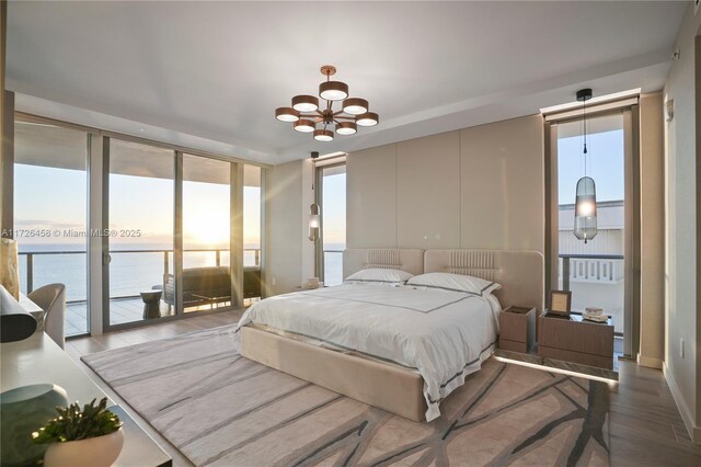 living room with expansive windows, wood walls, a water view, and a fireplace