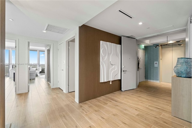 hall featuring visible vents and light wood finished floors