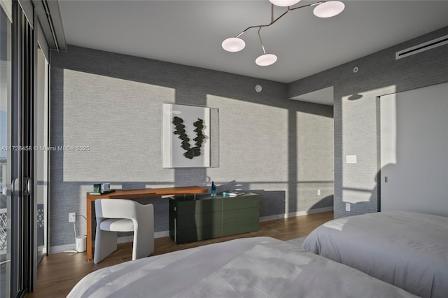 bedroom featuring brick wall, wood finished floors, visible vents, and baseboards