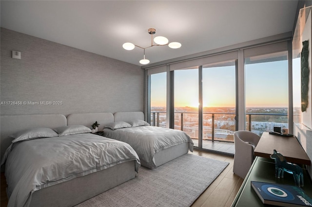 bedroom with access to outside, floor to ceiling windows, wallpapered walls, and multiple windows