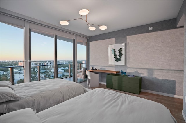 bedroom featuring a wall of windows, a city view, and wood finished floors