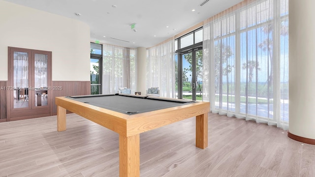 rec room with light wood-type flooring, french doors, wainscoting, and pool table