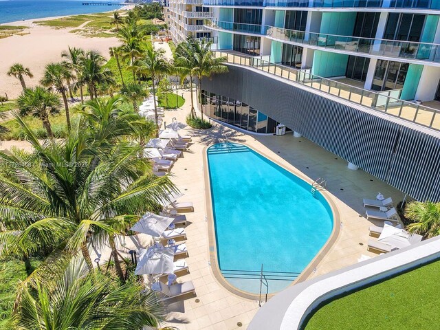 pool featuring a patio area and a water view