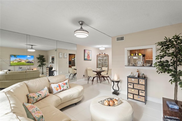 living room with a textured ceiling and light tile patterned floors