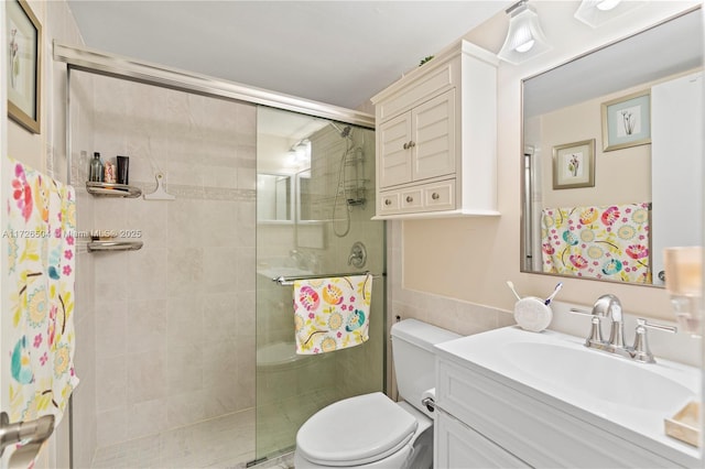 bathroom featuring tiled shower, vanity, and toilet