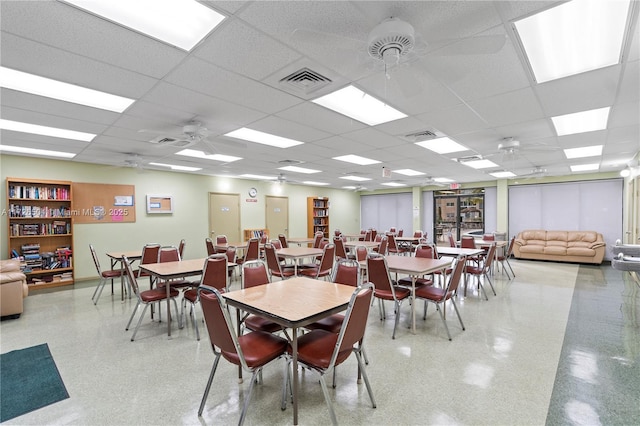 dining area with ceiling fan and a drop ceiling