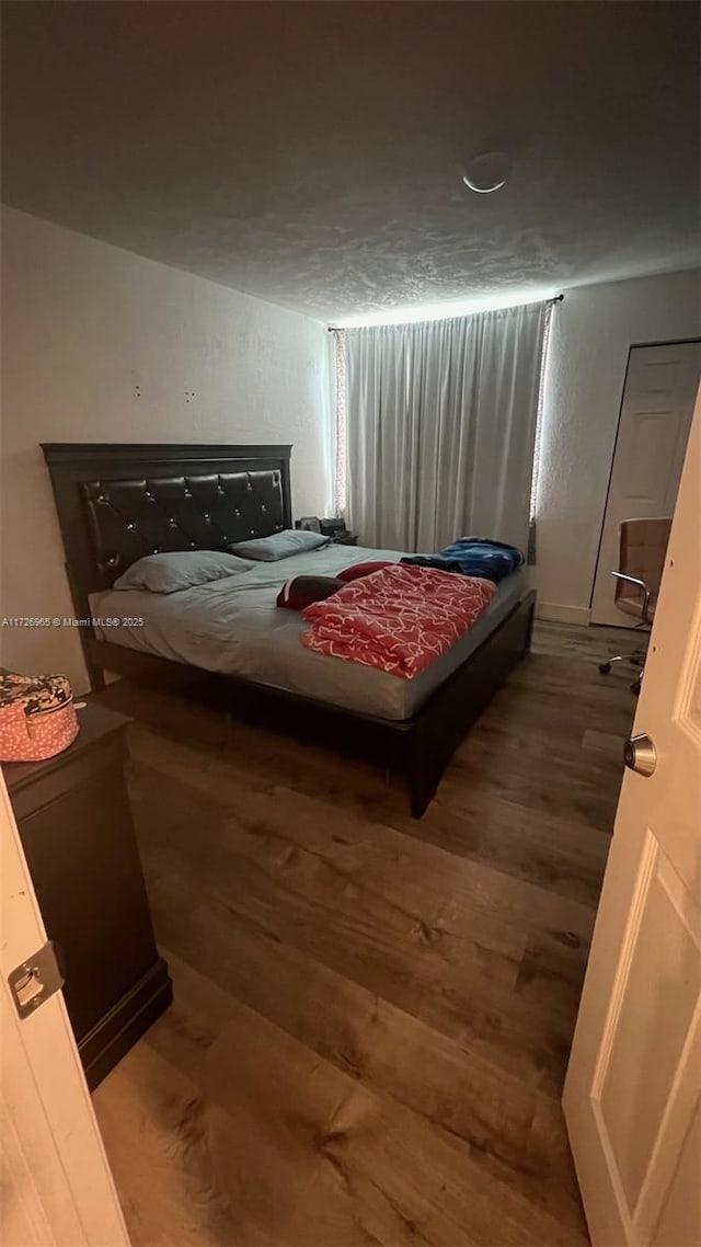 bedroom with dark wood-type flooring