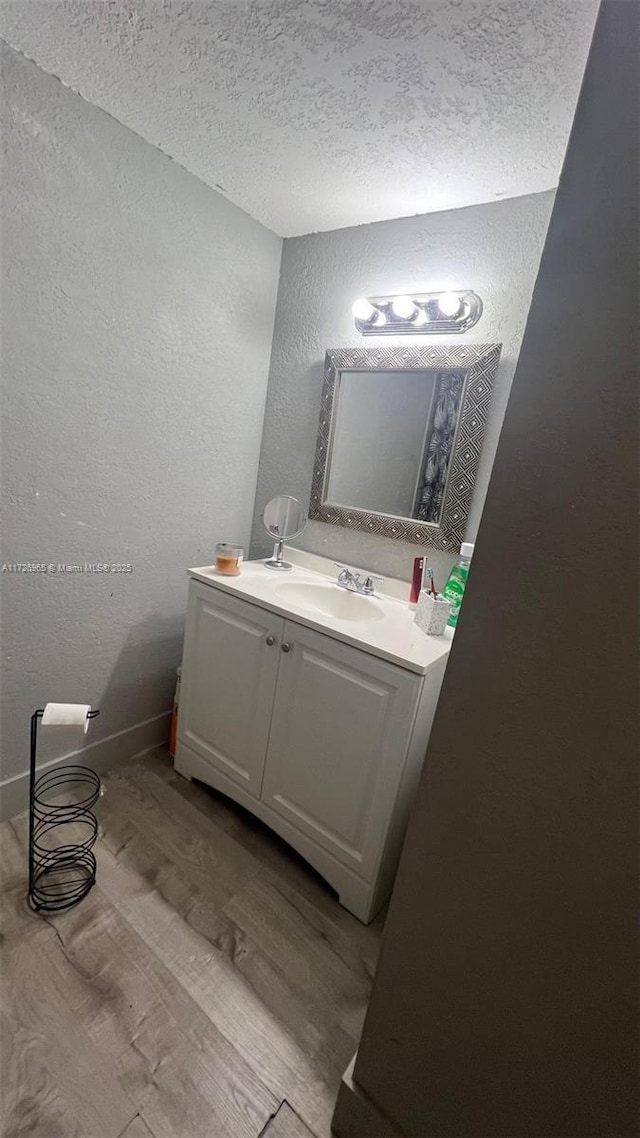 bathroom featuring wood-type flooring, a textured ceiling, and vanity