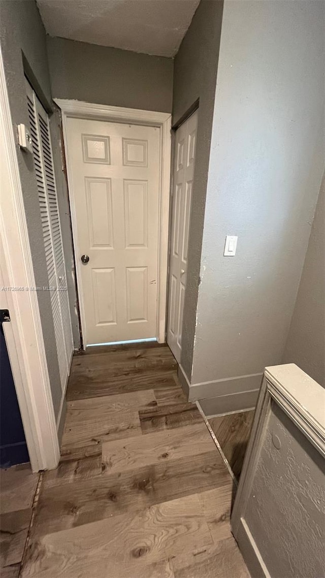 hallway with hardwood / wood-style floors