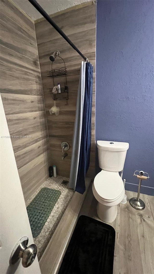 bathroom featuring toilet and a shower with shower curtain