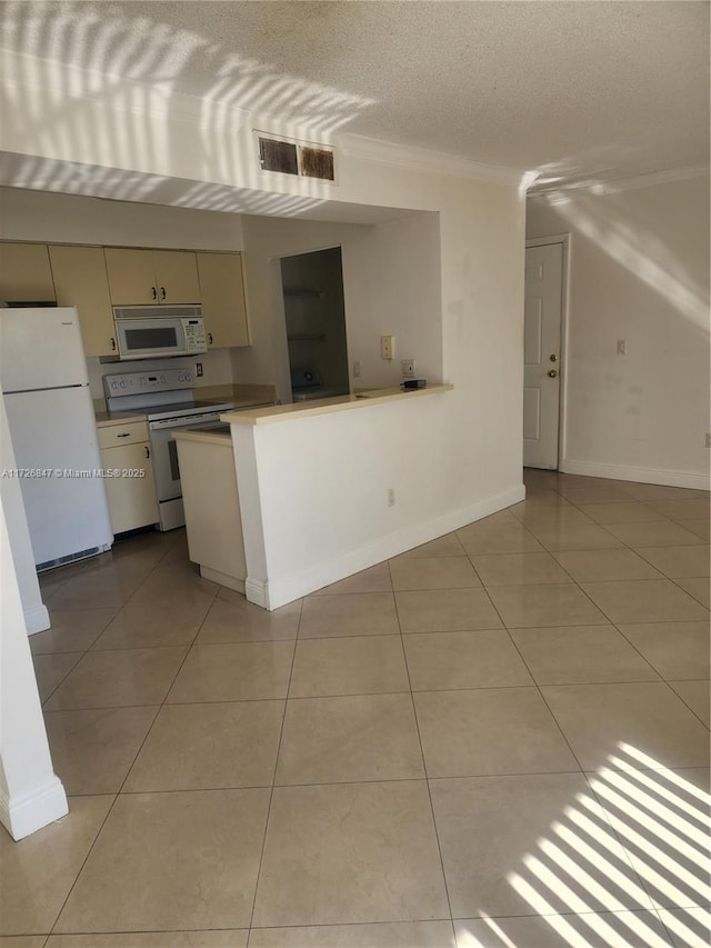 kitchen with white appliances, a textured ceiling, and light tile patterned flooring