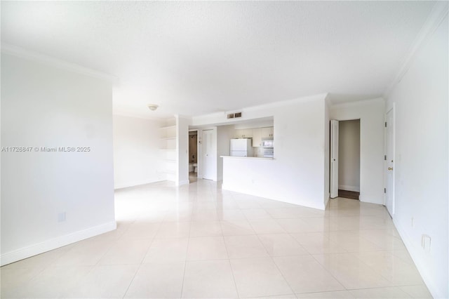 unfurnished room with a textured ceiling, light tile patterned floors, and ornamental molding