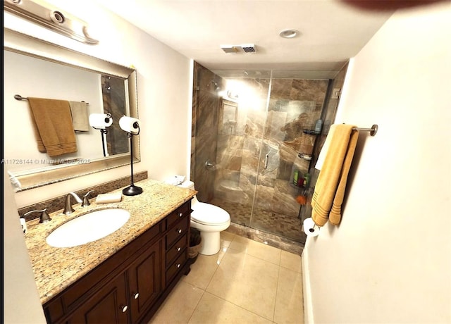 bathroom featuring toilet, tile patterned flooring, a shower with shower door, and vanity