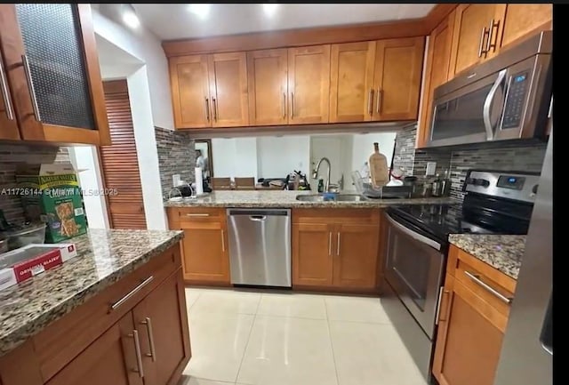1621 Collins Ave Unit 310, Miami Beach, FL 33139 - kitchen featuring stainless steel appliances, light stone counters, a sink, and tasteful backsplash