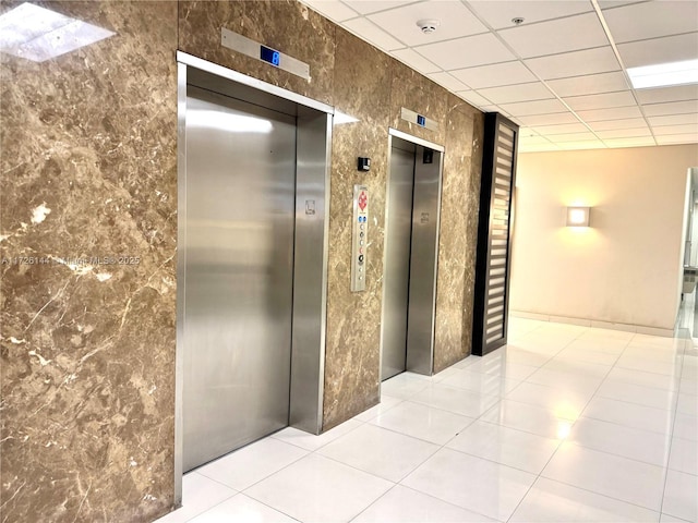 1621 Collins Ave Unit 310, Miami Beach, FL 33139 - hall featuring a paneled ceiling, tile patterned floors, and elevator