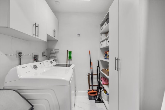 clothes washing area with washer and dryer and cabinets