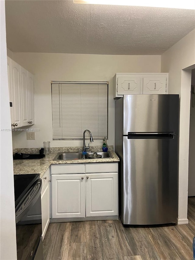 kitchen featuring white cabinets, electric stove, stainless steel fridge, and sink