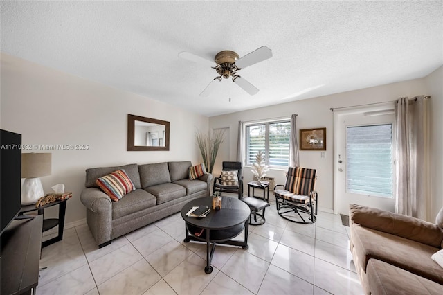 living room with ceiling fan, a textured ceiling, and light tile patterned floors