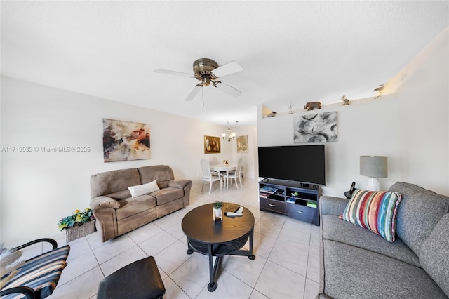 living room featuring a textured ceiling, ceiling fan with notable chandelier, and tile patterned floors