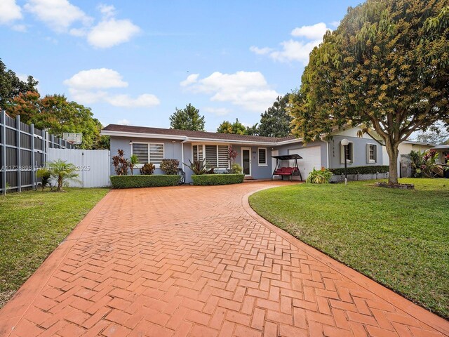 ranch-style house featuring a front yard and a garage