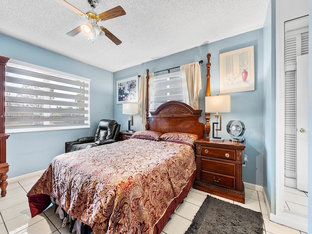 tiled bedroom featuring a textured ceiling, ceiling fan, and a closet