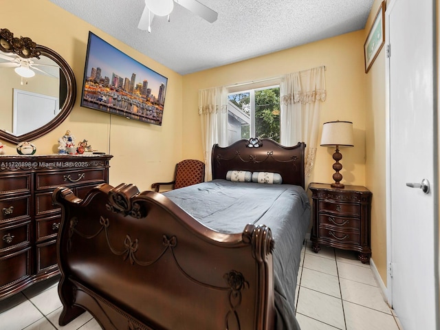 bedroom with ceiling fan, a textured ceiling, and light tile patterned floors