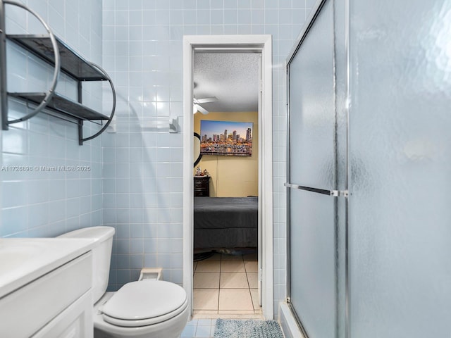 bathroom featuring toilet, tile walls, tile patterned flooring, a shower with shower door, and a textured ceiling