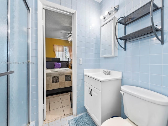 bathroom with a textured ceiling, tile patterned floors, vanity, toilet, and walk in shower