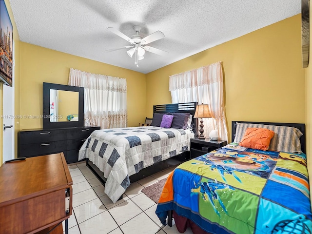 bedroom featuring a textured ceiling, ceiling fan, and light tile patterned floors