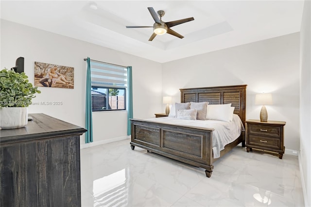 bedroom featuring ceiling fan and a tray ceiling