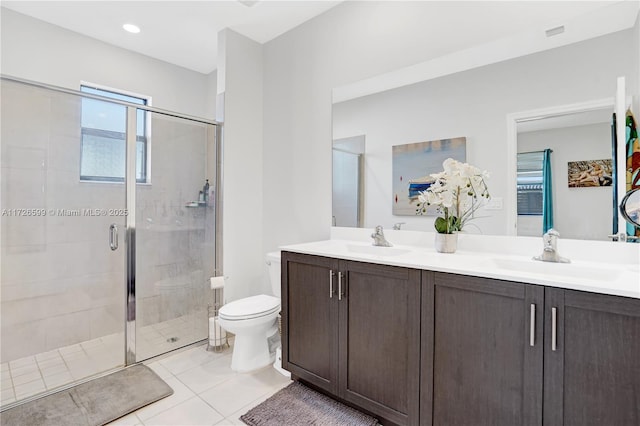 bathroom with toilet, vanity, tile patterned floors, and a shower with shower door