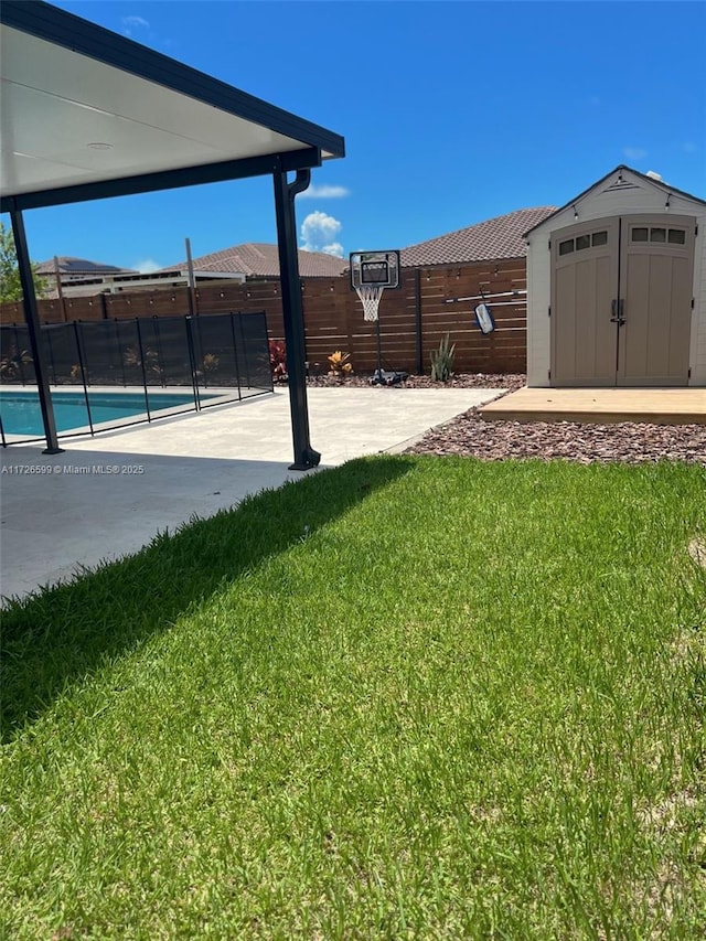 view of yard featuring a pool, a patio, and a shed