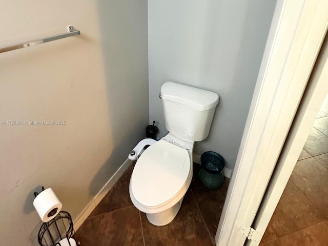 bathroom featuring toilet, tile patterned flooring, and baseboards