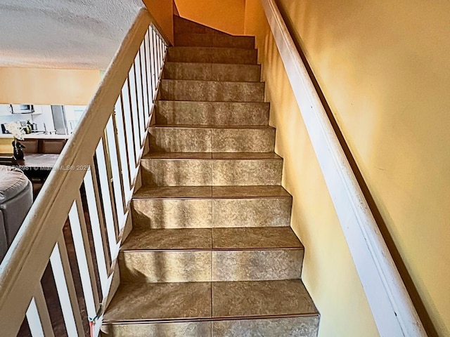 stairway with a textured ceiling